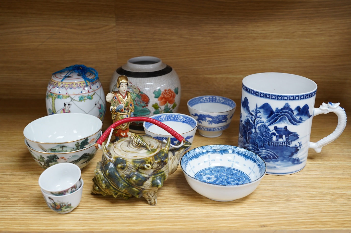 A collection of Chinese and Japanese ceramics to include tea bowls, a blue and white mug and teapot in the form of a shell, largest 13cm high. Condition - mostly good